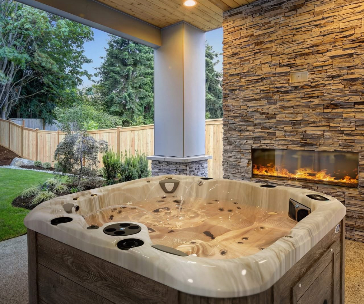 Caldera Spas hot tub beside an outdoor fireplace